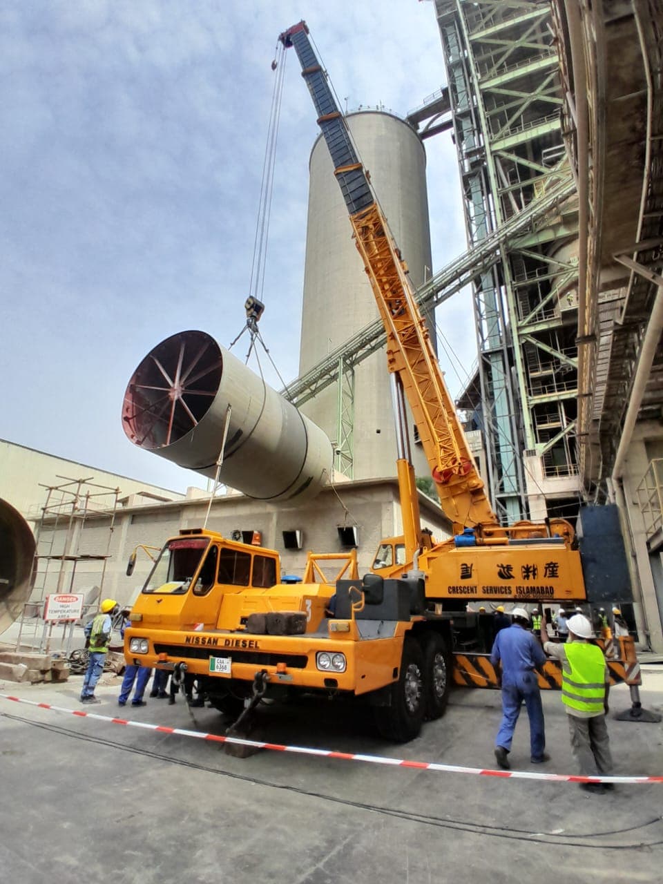 Mobile crane lifting a large cylinder